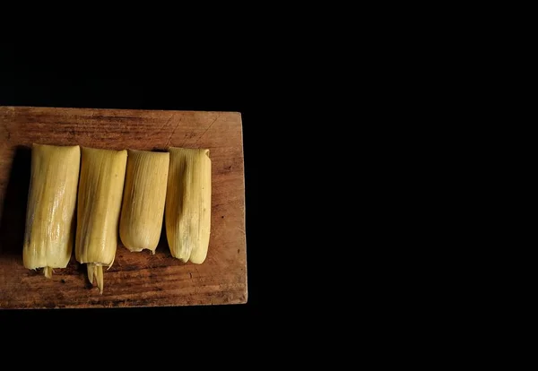 Autentyczne Tamale Liściem Kukurydzy Drewnianej Desce Czarnym Tłem Typowe Jedzenie — Zdjęcie stockowe