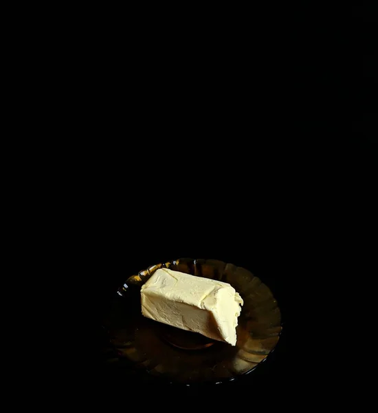 黑色背景的盘子上的黄油 — 图库照片