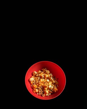 Siyah arka planda peynirli patlamış mısır kasesi, sinema konsepti