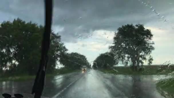 在大雨中 从汽车前窗看到的景象是带着工作的挡风玻璃雨刷的 倾盆大雨中 从车内望去 乌云密布 雨天使用挡风玻璃雨刷 — 图库视频影像