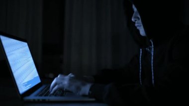 Hacker bilgisayar ağına sızıyor. Karanlık bir odada dizüstü bilgisayarda yazan genç bir adam. Bilgisayarı olan bir bilgisayar korsanı. Soyguncu. Yalnız gençler internette sohbet ediyor. Bilgisayar suçlusu. 4k görüntü.
