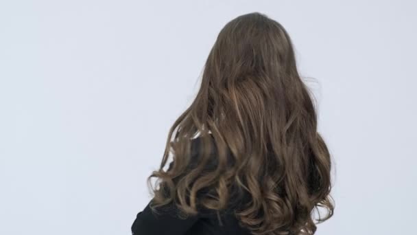 여성이 뒤돌아 카메라를 들여다 봅니다 머리의 아름다운 스튜디오에서 포즈를 취하고 — 비디오