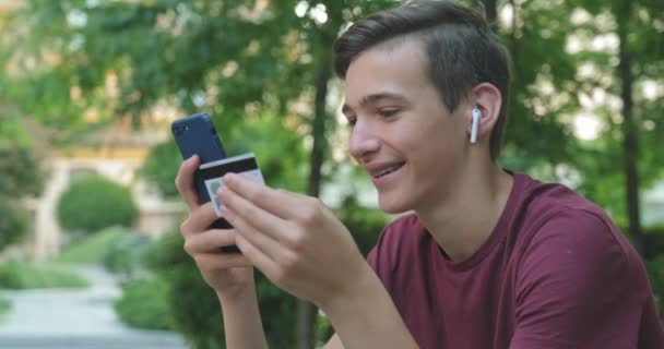 Teen Tätigt Online Einkäufe Mit Kreditkarte Und Handy Lächelnder Junger — Stockvideo