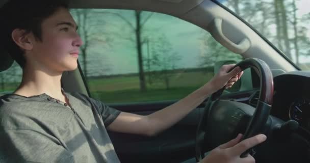 年轻人第一次开着车 新手司机在开车 年轻人在开车 年轻的成年男孩开车 侧视那个开车的家伙 — 图库视频影像