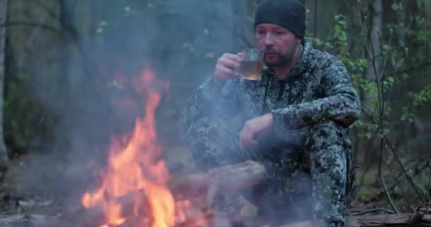 Homem Bebe Chá Quente Perto Fogo Floresta Ser Humano Olha — Vídeo de Stock