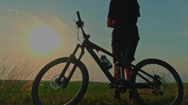 Ciclista Disfruta Puesta Sol Joven Que Apoya Una Bicicleta Mira — Vídeo de stock