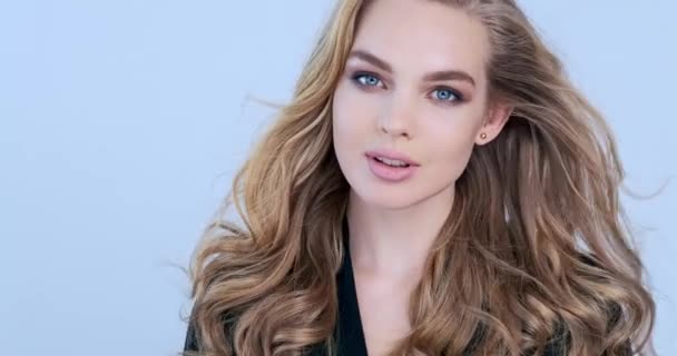 長い髪の美しい若いブロンドの女性 ファッションモデルは カメラに見えます 白人の少女の見事な顔 美しい青い目のセクシーなモデル スローモーション 美しさの概念4K映像 — ストック動画