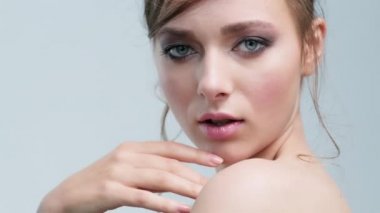 Genç beyaz kız dönüp kameraya bakıyor. Mavi gözlü bir kadın yüzü. Güzel ve seksi model poz veriyor. Taze tenli güzel bir kadın. Parlak makyajlı kadın gözleri. ZOM IN