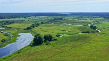 İHA 'dan hava görüntüsü. Bir motosikletlinin kır yolunda araba sürüşünü takip ediyor. Hızlı bisiklet büyük toz bulutlarıyla gidiyor. İnsansız hava aracından motosikletle yarışa en üst görünüm.    