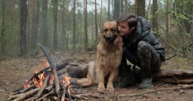 Genç, bir köpekle ateşin yanında oturuyor. Genç adam şöminenin yanında bir çoban köpeğiyle dinleniyor. Bir sonbahar akşamında evcil hayvanı olan biri..