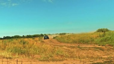 Böcek arabası, ülkenin diğer ucundaki bir yolda hızla ilerliyor. Hızlı rali arabası büyük toz bulutlarıyla gidiyor. Kırsal yolda bir yarış off-road arabasının sürüşü. Sinema klibi. 