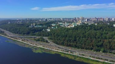 Dnepr nehrinin üzerinden Pecherskaya Lavra ve Anavatan heykeline insansız hava aracı uçurmak. Ukrayna 'nın 2020 yazında Kiev kentine sinematik hava manzarası. İnsansız hava aracı sürüş arabalarıyla otoyola çıkıyor.