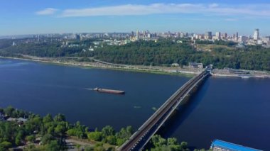 Dnepr nehri üzerinde uçan insansız hava aracı ve Metro köprüsü Pecherskaya Lavra ve Anavatan heykeline doğru ilerliyor. 2020 yazında güzel Kiev şehri. Sürücü arabaları ile otoyola üst görünüm
