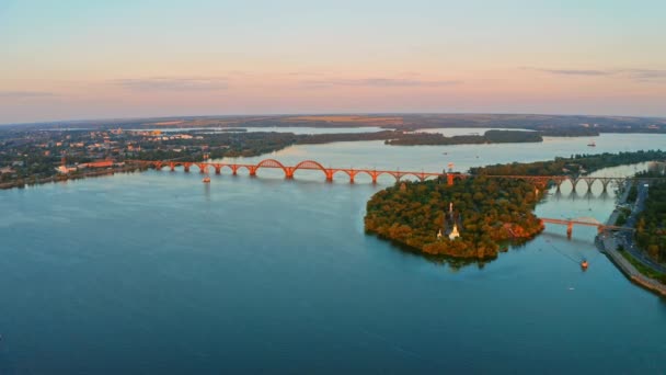 从空中俯瞰美丽的老教堂蓝河和长桥 而日落 无人机带着水和桥在美丽的城市上空飞行 乌克兰 第聂伯市 2020年 — 图库视频影像