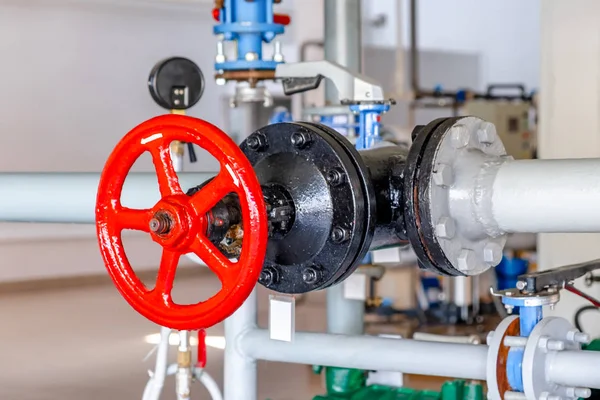 Elektrik santralinin teknolojik boru hattında kırmızı kilit tekerleği olan kapı valfi..