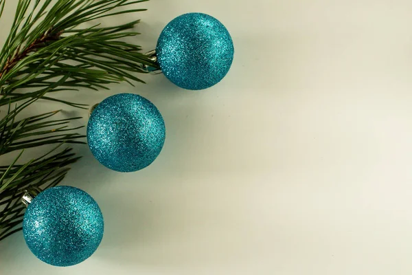 Christmas blue balls on a green branch of the Christmas tree with a white background