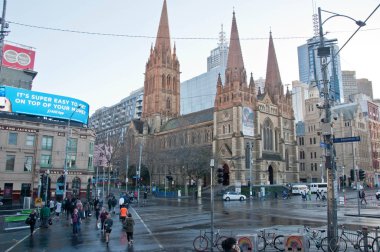 Melbourne, Avustralya - 29 Temmuz 2018: Federasyon Meydanı Melbourne merkezi iş bölgesinde St Paul Katedrali. Kavşak square yakınındaki geçmeye yürüyen insanlar var. Fotoğraf öğleden sonra yağmur sonra alınır.