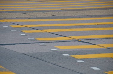 Beton yol arka planında soyut sarı boyalı trafik çizgisi deseni