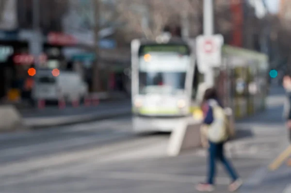 Orang-orang buram yang terdekatkan berjalan di dekat trem di Melbourne Stok Lukisan  