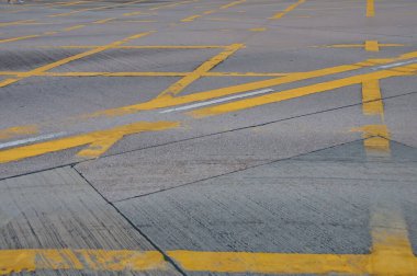 Beton yol arka planında soyut sarı boyalı trafik çizgisi deseni