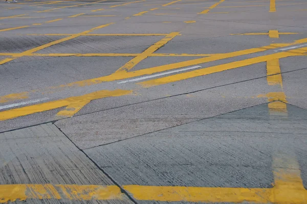 Beton yol arka planında soyut sarı boyalı trafik çizgisi deseni