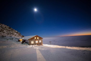 Kamenna Chata - Chopok, Nizke Tatry, bir dağın tepesindeki kır evi, kışın bulutların üstünde