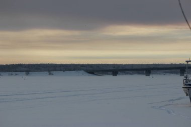 Akşamüstü bulutlu bir gökyüzü, bir sanayi limanı ve haliçinin arka planında.