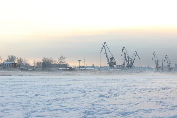 Akşamüstü bulutlu bir gökyüzü, bir sanayi limanı ve haliçinin arka planında.
