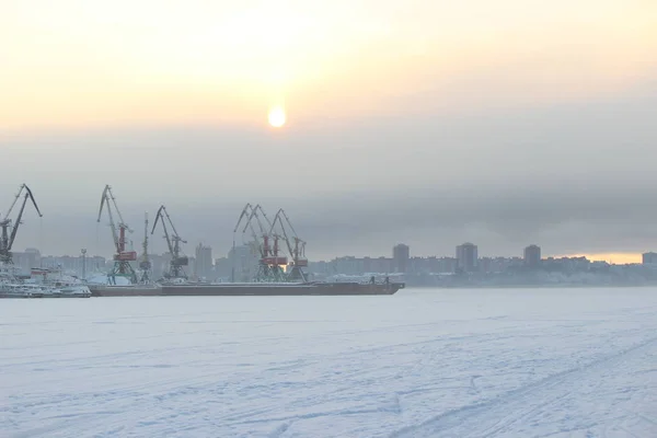 Akşamüstü bulutlu bir gökyüzü, bir sanayi limanı ve haliçinin arka planında.