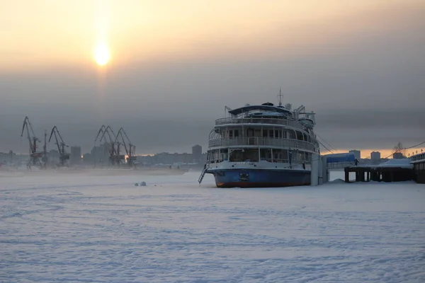 Akşamüstü bulutlu bir gökyüzü, bir sanayi limanı ve haliçinin arka planında.