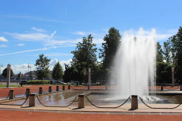 Güneşli bir yaz gününde, St. Petersburg şehrinin Neva Nehri seti üzerinde çalışan bir çeşme.