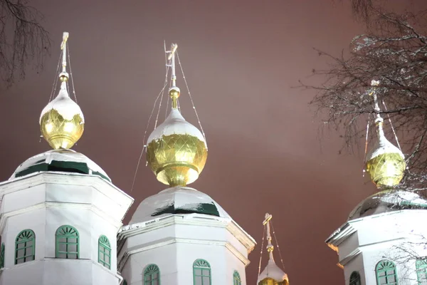 Bir Ortodoks kilisesinin aydınlanmış kubbeleri akşam gökyüzüne karşı