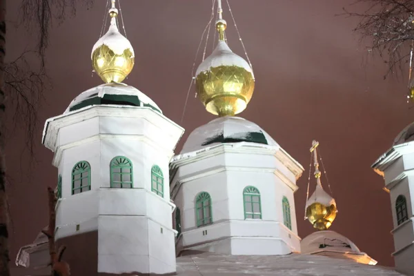 Bir Ortodoks kilisesinin aydınlanmış kubbeleri akşam gökyüzüne karşı