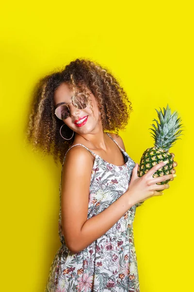 Beauty portrait of young african american girl with afro hairstyle in sunglasses. Girl posing on yellow background, — Stock Photo, Image