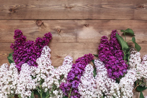 Ramo de flores de lilas púrpuras sobre un fondo de madera marrón —  Fotos de Stock