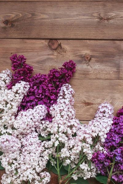 Ramo de flores de lilas púrpuras sobre un fondo de madera marrón —  Fotos de Stock