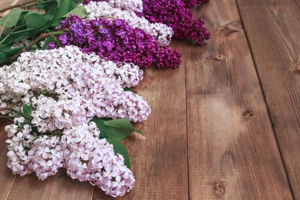 Ramo de flores de lilas púrpuras sobre un fondo de madera marrón —  Fotos de Stock