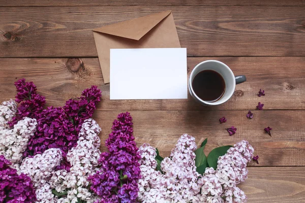 Ramo de flores lila sobre tablones de madera con tarjeta en blanco para texto y café — Foto de Stock