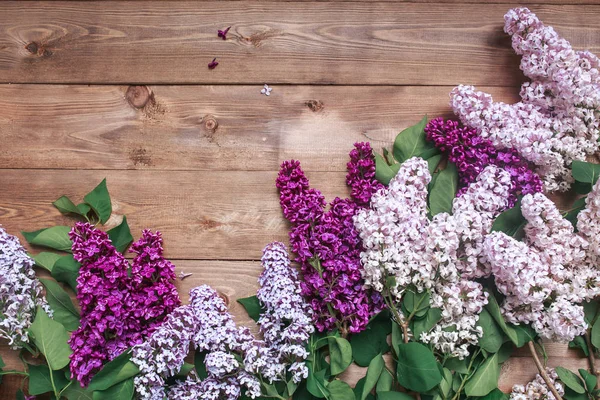 Ramo de flores de lilas púrpuras sobre un fondo de madera marrón —  Fotos de Stock