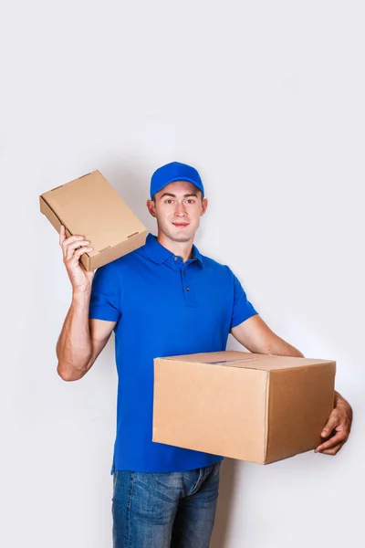 Χαρούμενα παράδοση από τον άνθρωπο. Χαρούμενος νεαρός courier κρατώντας ένα κουτί από χαρτόνι και χαμογελαστός — Φωτογραφία Αρχείου