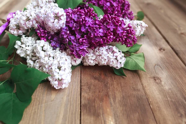 Ramo de flores de lilas púrpuras sobre un fondo de madera marrón —  Fotos de Stock