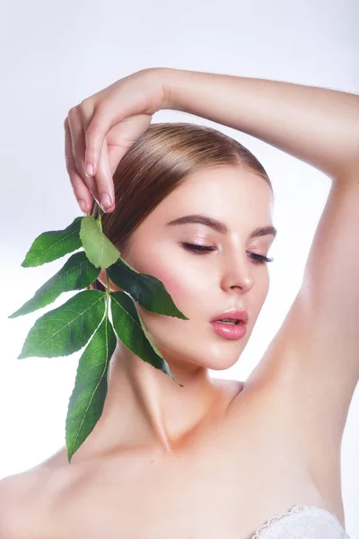 Retrato de rosto de mulher bonita com conceito de folha verde para cuidados com a pele ou cosméticos orgânicos. Retrato de estúdio — Fotografia de Stock