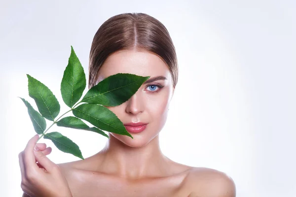 Retrato de rosto de mulher bonita com conceito de folha verde para cuidados com a pele ou cosméticos orgânicos. Retrato de estúdio — Fotografia de Stock