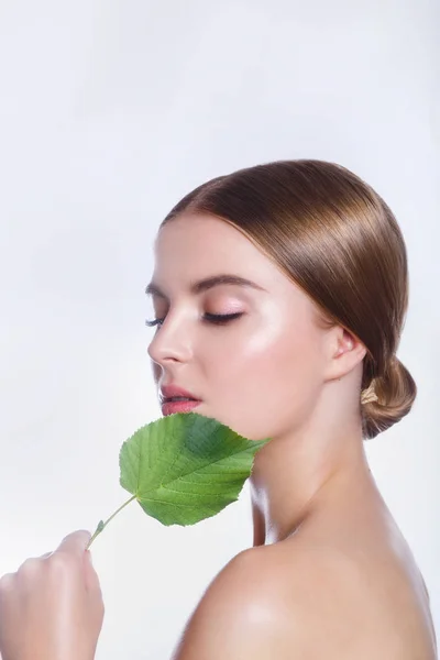 Krásná žena tvář portrét s konceptem zelený list pro péči o pleť nebo organické kosmetiky. Studiový portrét — Stock fotografie