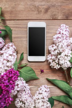 Cep telefonu ile ahşap plakalar üzerinde Lila buket.
