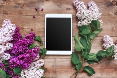 Tablet ile ahşap plakalar üzerinde eflatun çiçekler Buket. Üstten görünüm