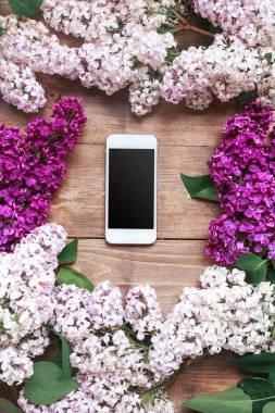 Cep telefonu ile ahşap plakalar üzerinde Lila buket.