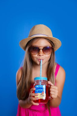 Şapka ve güneş gözlüğü yaz limonata ile olan küçük kız. Yaz tatil ve seyahat kavramı