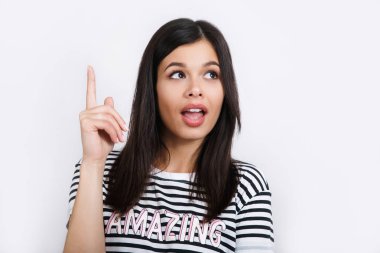 İyi görünümlü esmer erkek saf sağlıklı deri ile yukarı doğru bir şey de belirttiği gibi hayretle bakar. Genç ve güzel kadın kadar hareketleri kapalı şaşırtıcı şey görür