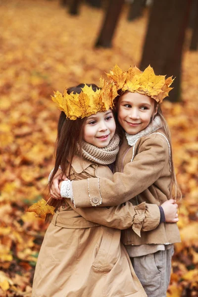 Sevimli iki küçük kız sonbahar parkta sarılma